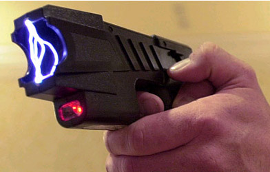 a hand holding an illuminated toy gun with its red light on