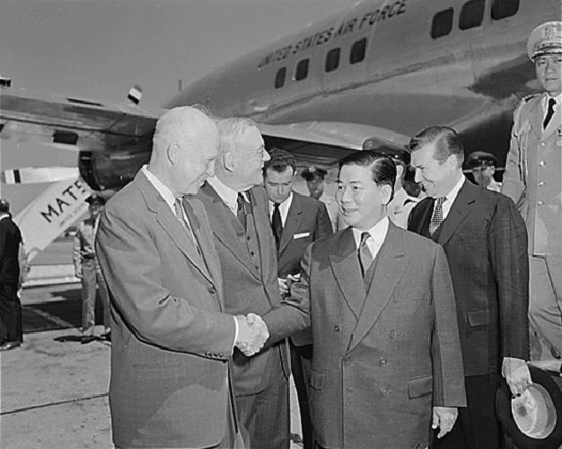 men in suits and ties shaking hands outside an airplane