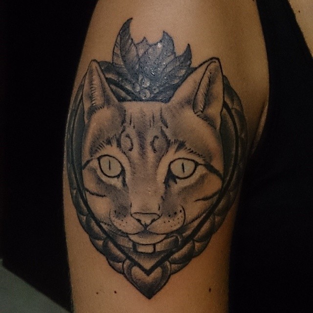 a gray cat is on the elbow in a tattoo