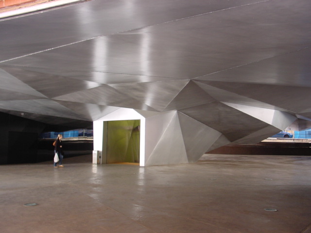 an empty concrete tunnel with an open doorway and people in the area