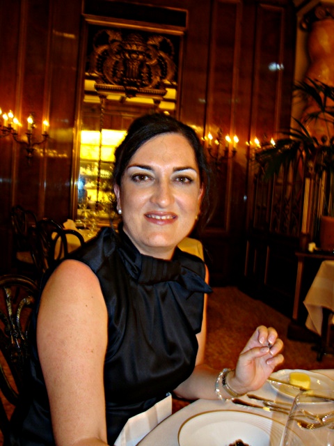 a woman is sitting at a table with a cake