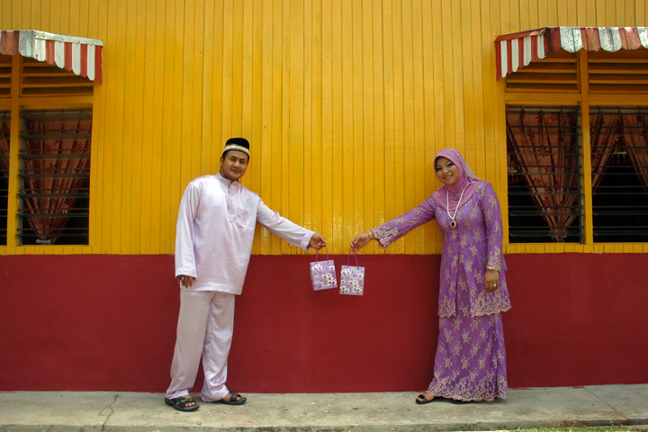 two people shaking hands next to a yellow building
