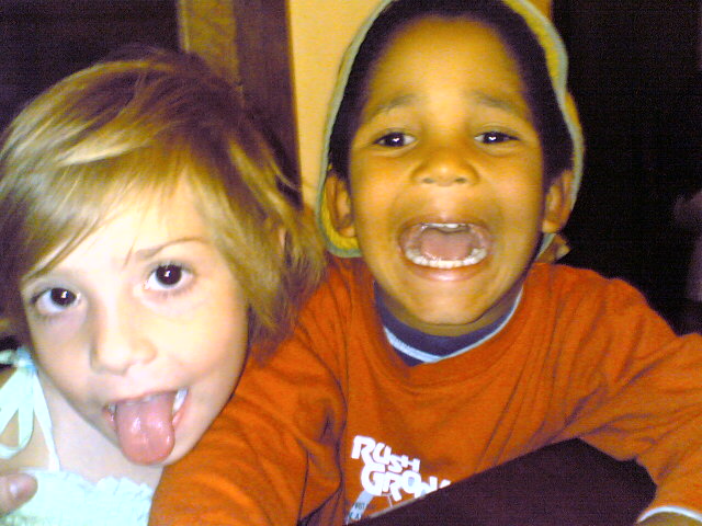 two little boys posing for the camera and sticking out their tongues