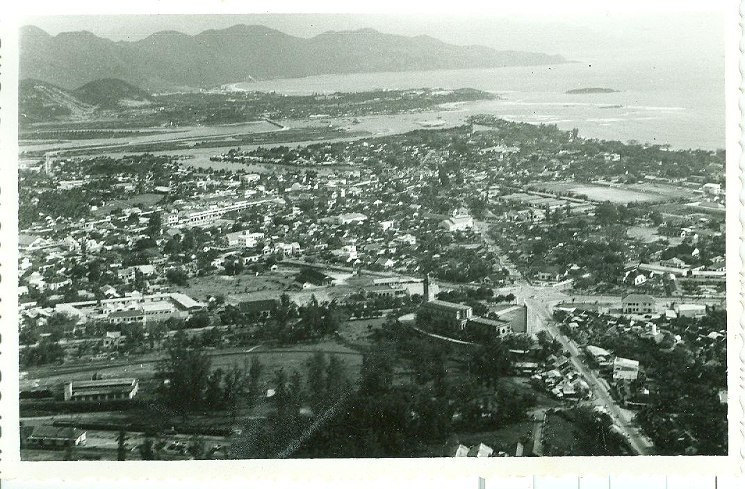 an aerial view of a small town with the ocean in the background