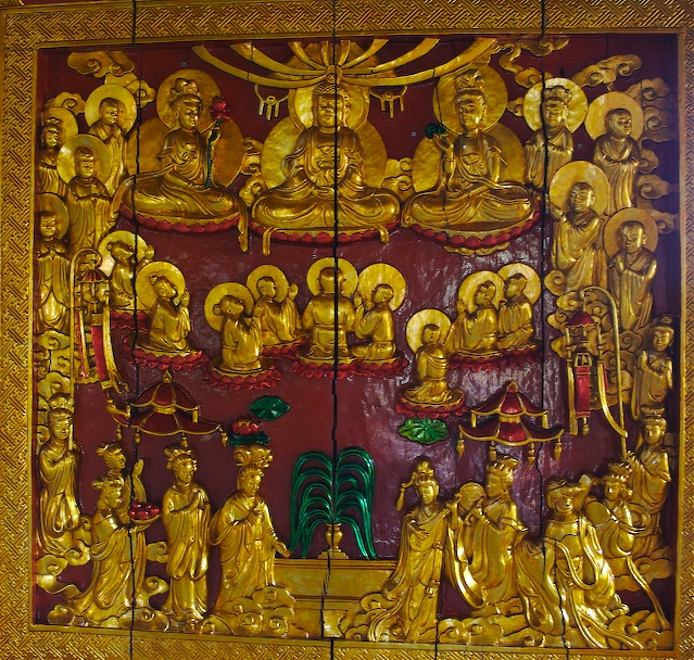 a gold carved panel showing the five buddhas