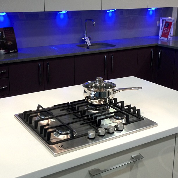 the kitchen has a blue backlit lights above a stove