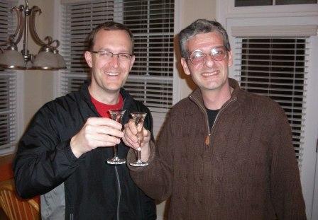 two men are drinking some alcohol and posing for the camera