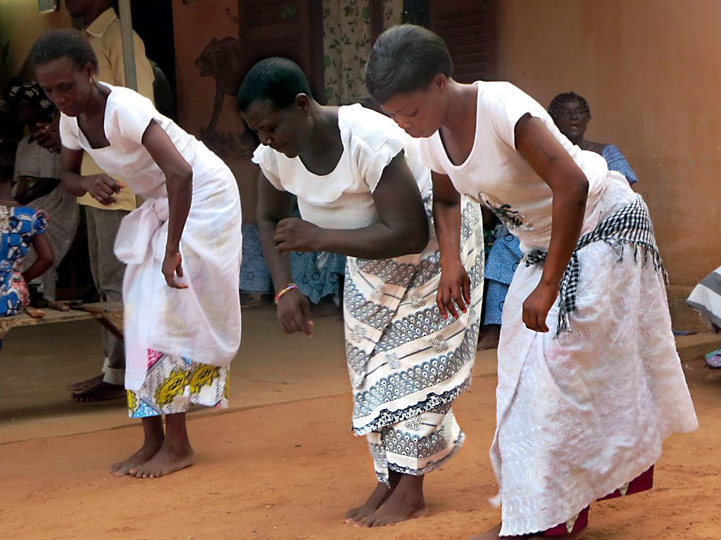 a group of women wearing dresses standing around a brick building