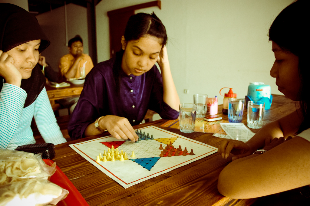 three women sitting around a table playing board games