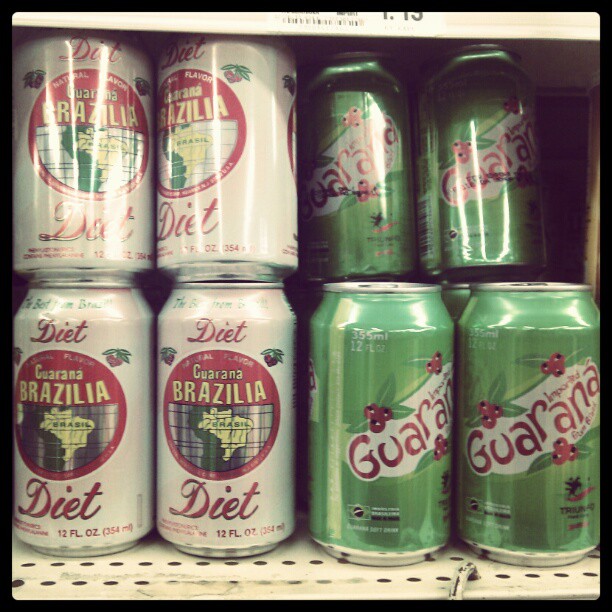 several green and red cans of drinks sit on a shelf