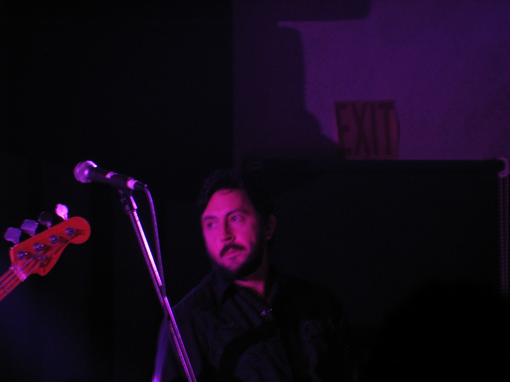 the musician is talking into his microphone at the concert