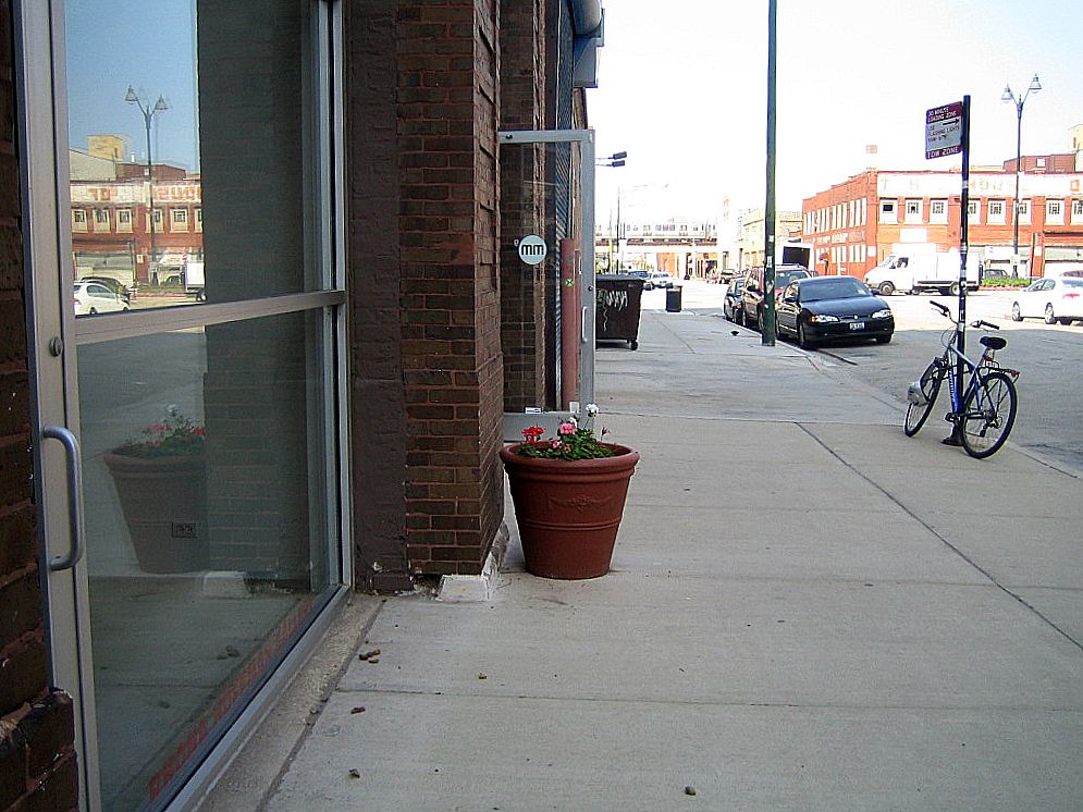a bicycle parked near an empty sidewalk in front of a building