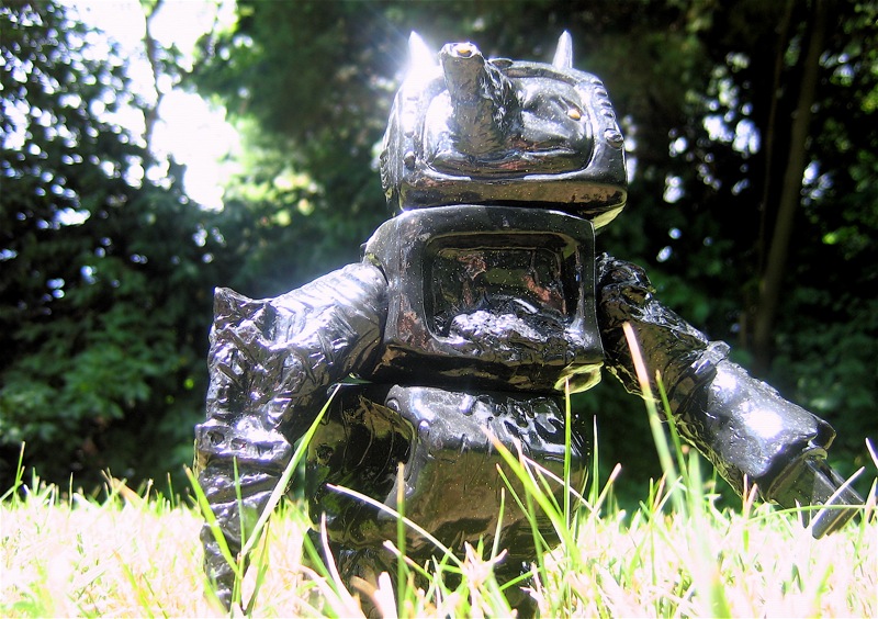 a statue of a robot is out in the grass