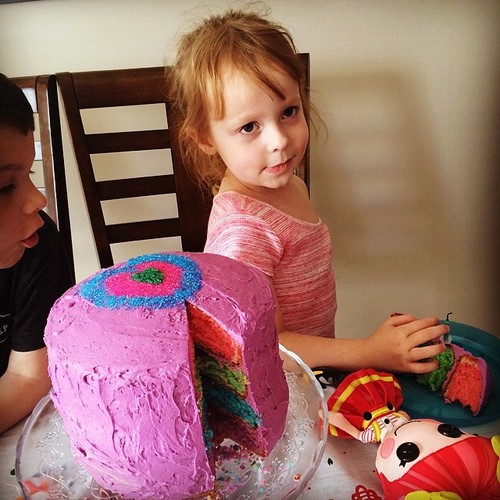  in front of pink birthday cake on table