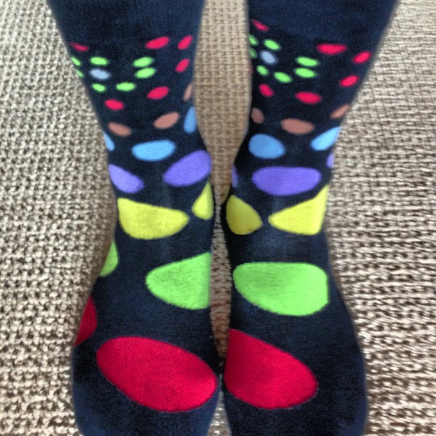 a person is wearing black socks and multi colored dots