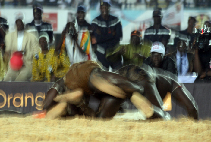 two men wrestling in an arena during a sporting event