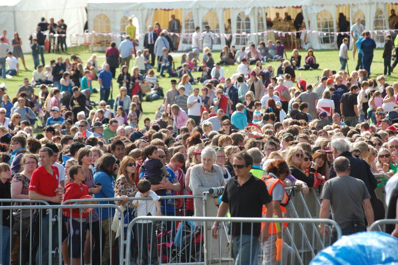 a crowd of people walking next to each other at an outdoor event