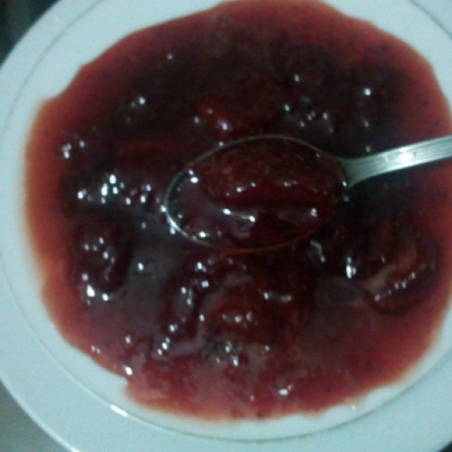 a spoon is being used to get jelly out of the bowl