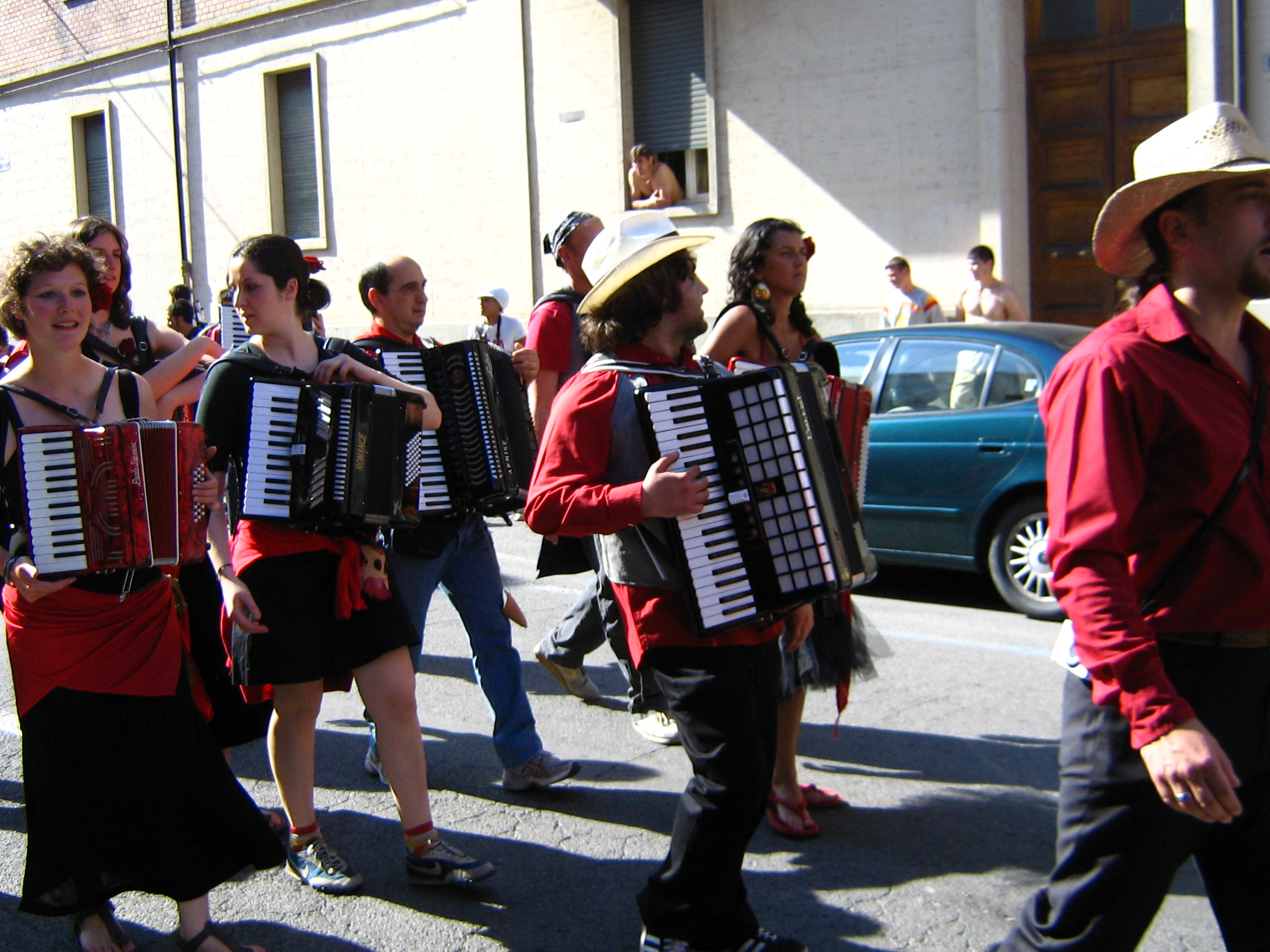 a group of people walking down a street holding an accordion