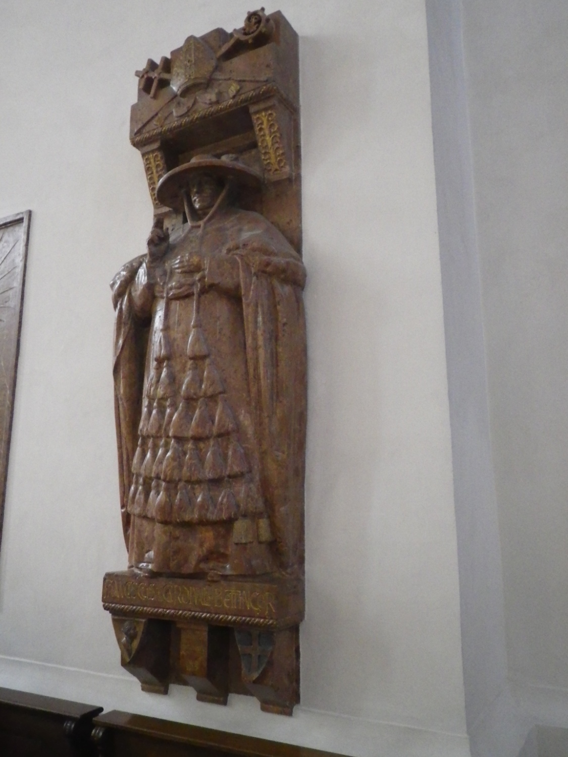 a wooden statue is holding an open book on top