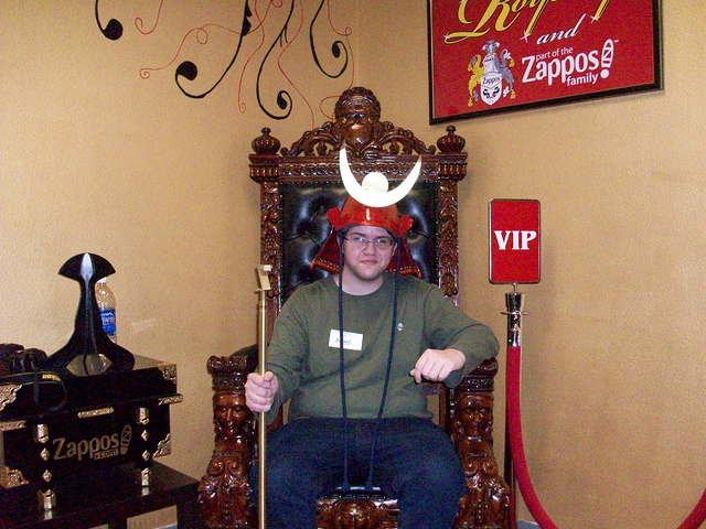 a man is sitting on a chair with an antlers horns over his head