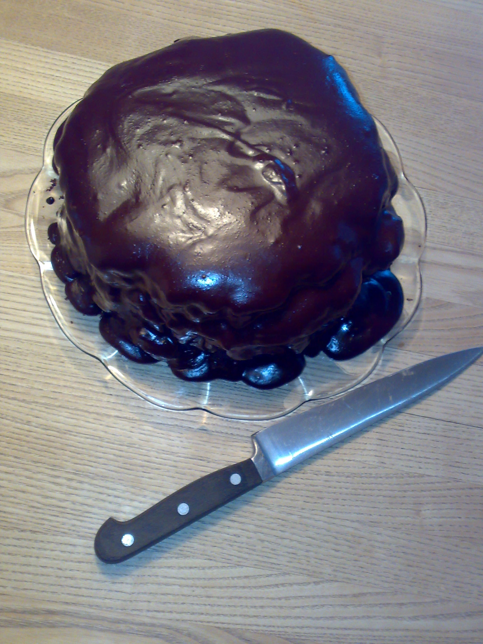 a chocolate cake sitting on top of a plate with a knife