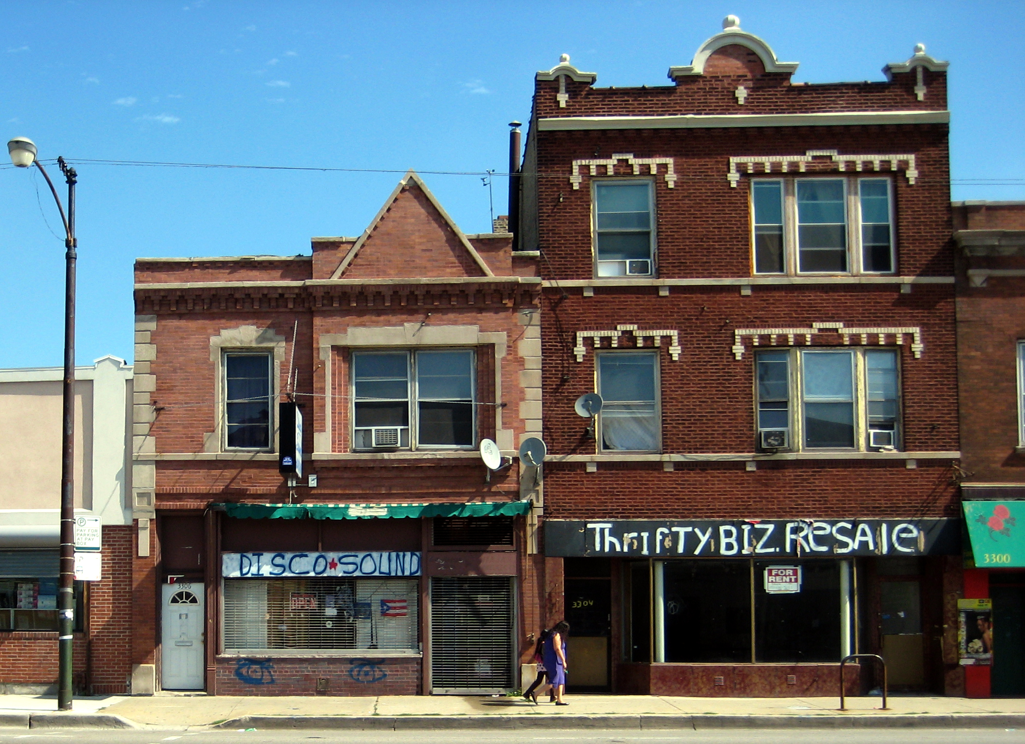 a store with a green sign in front of a building