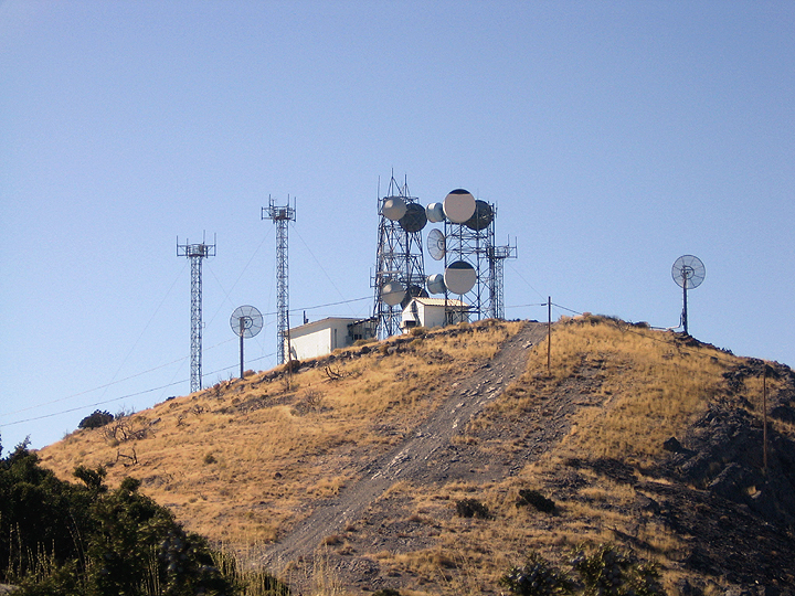 multiple cell towers sitting on top of a hill