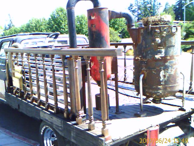 a truck trailer with several pipe attached to it's rear wheels