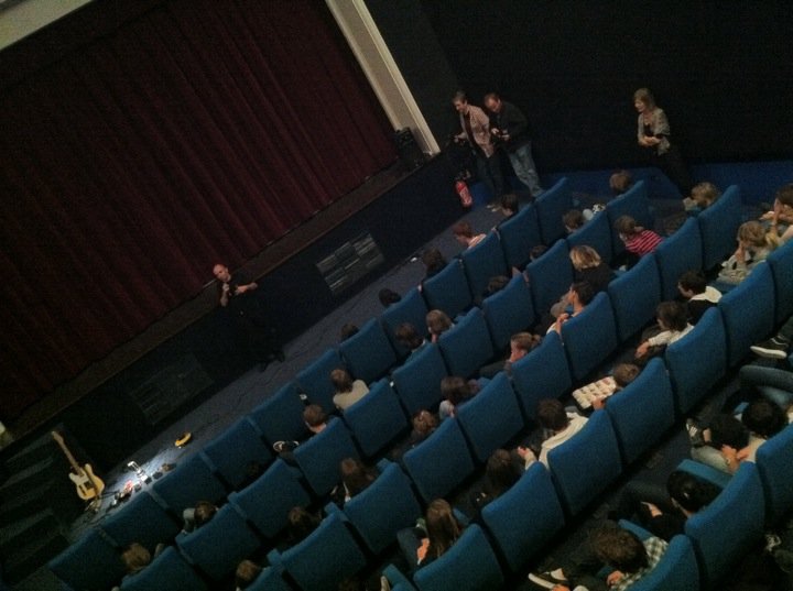 several people in an auditorium looking down at the stage