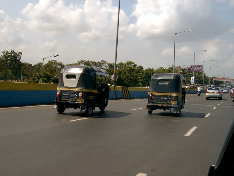 two trucks and some cars driving down the road