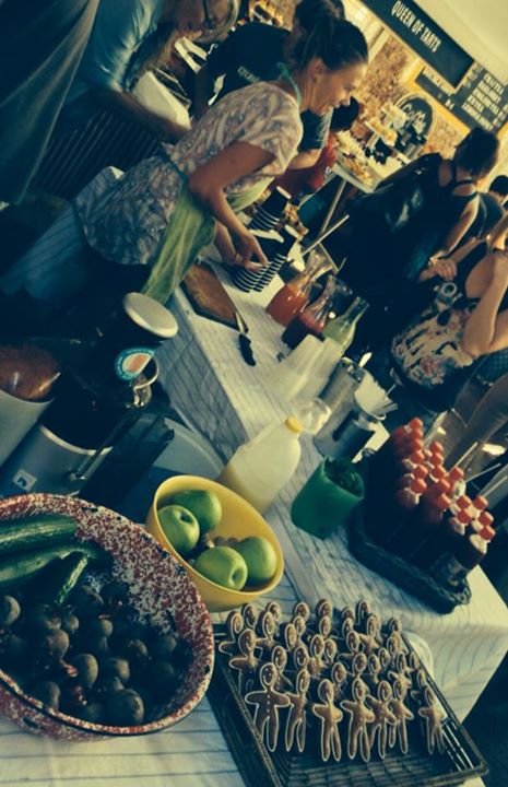 several people standing at a counter with trays of food