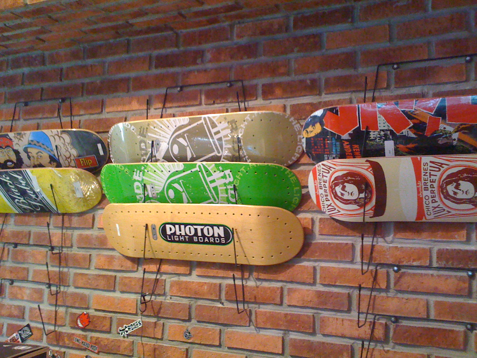 some skate boards hanging from the brick wall