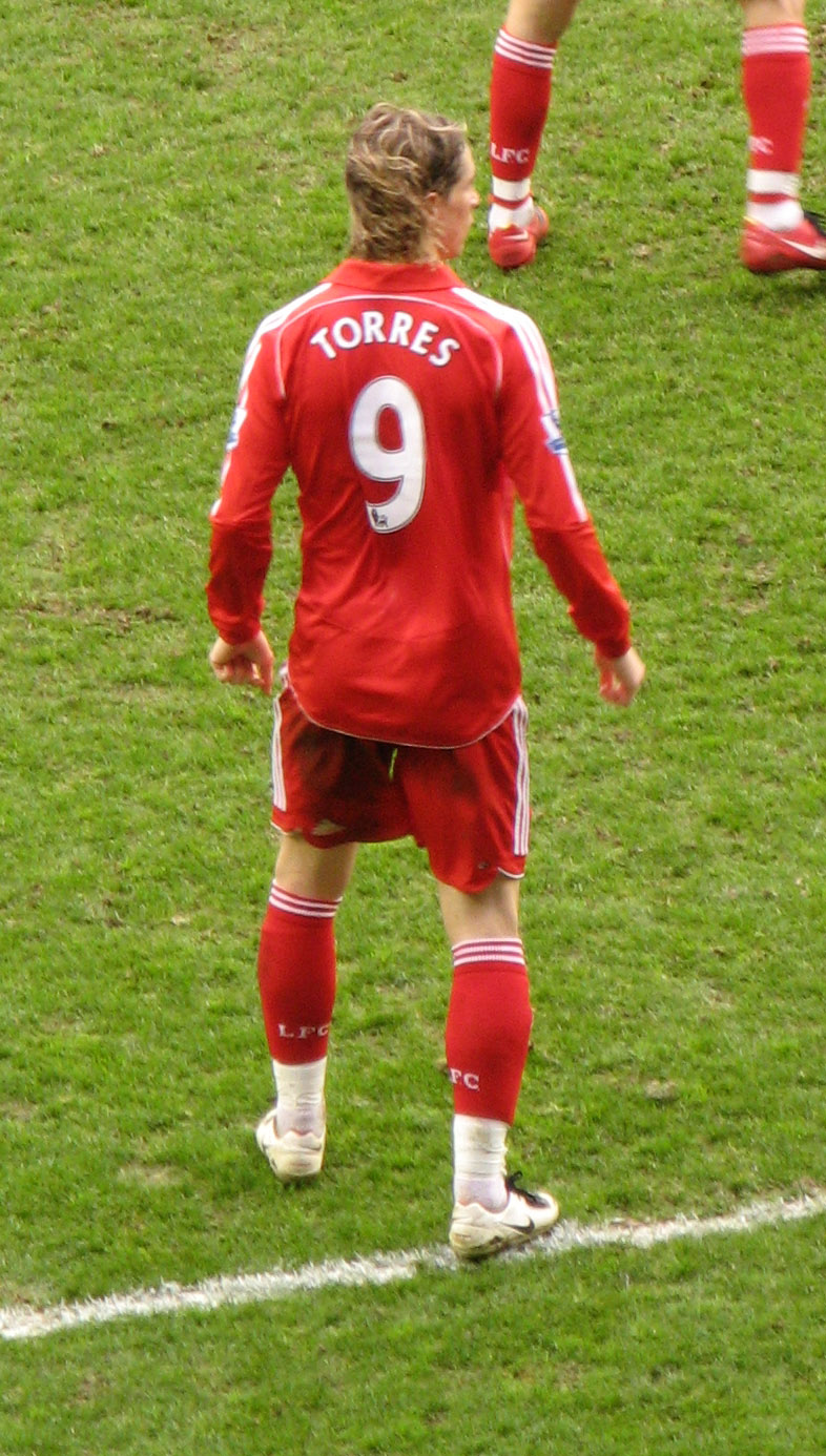 a soccer player in red is ready to kick the ball