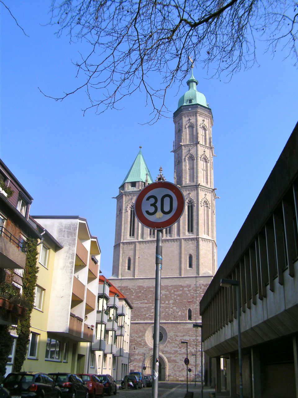 a street sign near the side of the road with a church in the background