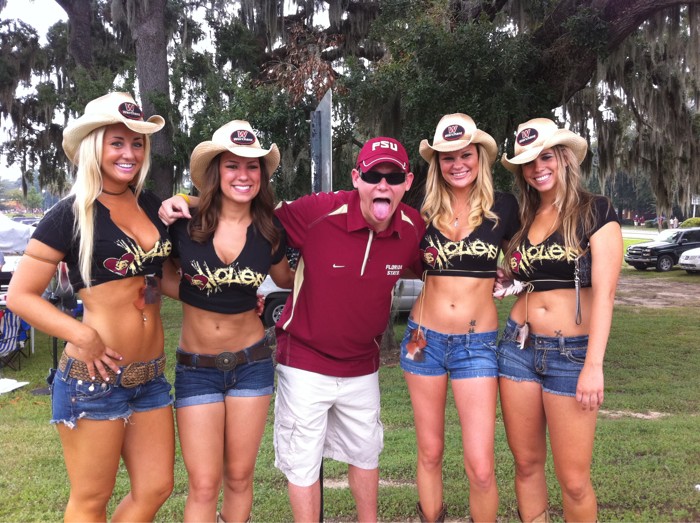 a man is standing between some girls wearing cowboy hats