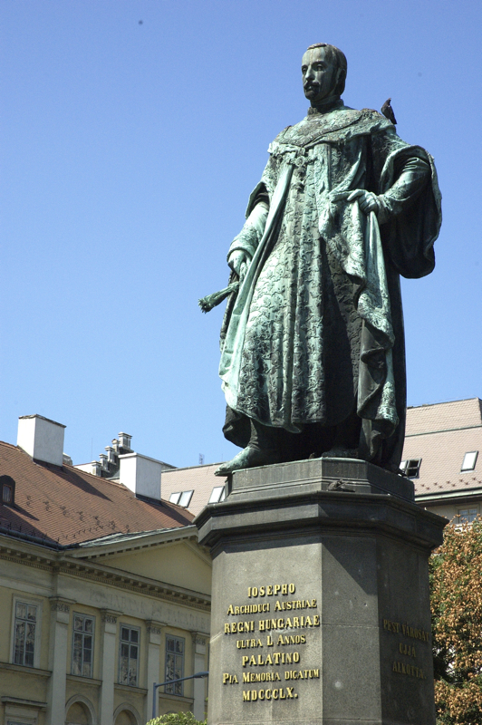 a statue of a man in green robes and cloak with a clock