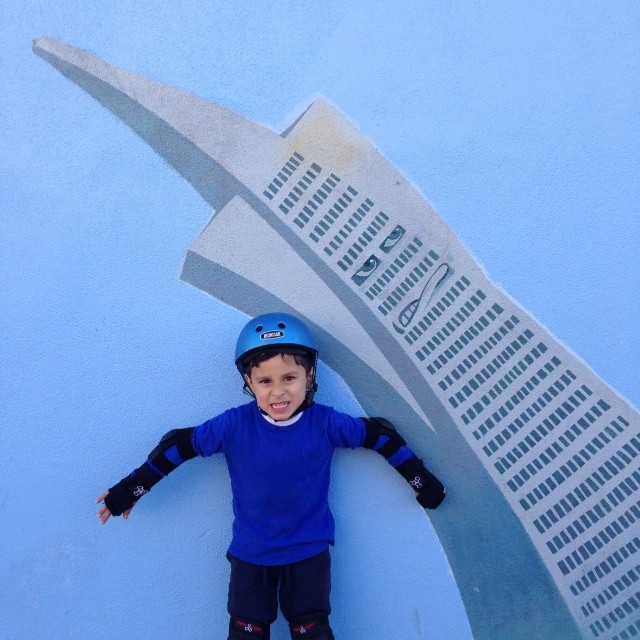 a small child with his hands up and a helmet