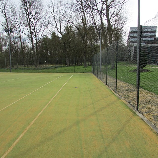an empty tennis court with one yellow line