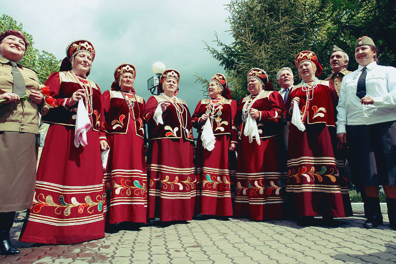 a group of people dressed in costumes posing on a cobble stone area