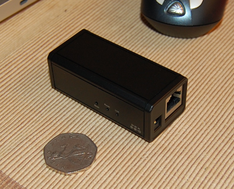 a coin sitting next to a compact device on a table