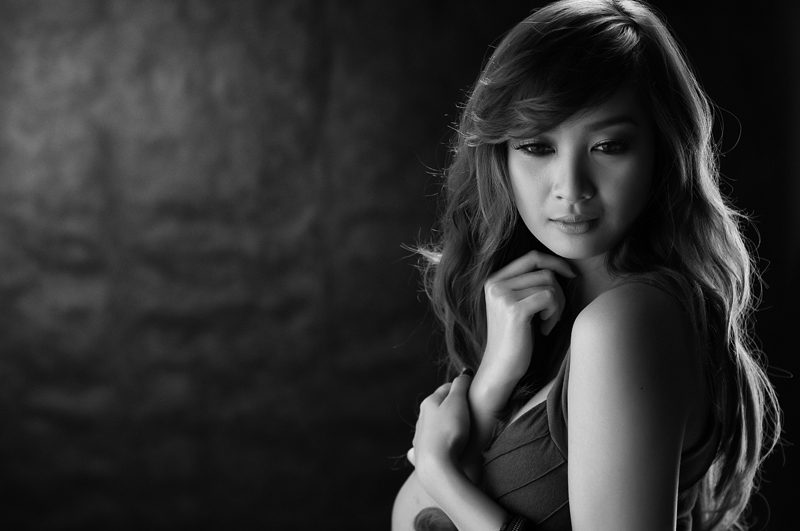 a woman with long hair is posing in black and white