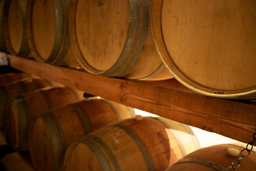 a few wooden barrels of wine hang on a wall