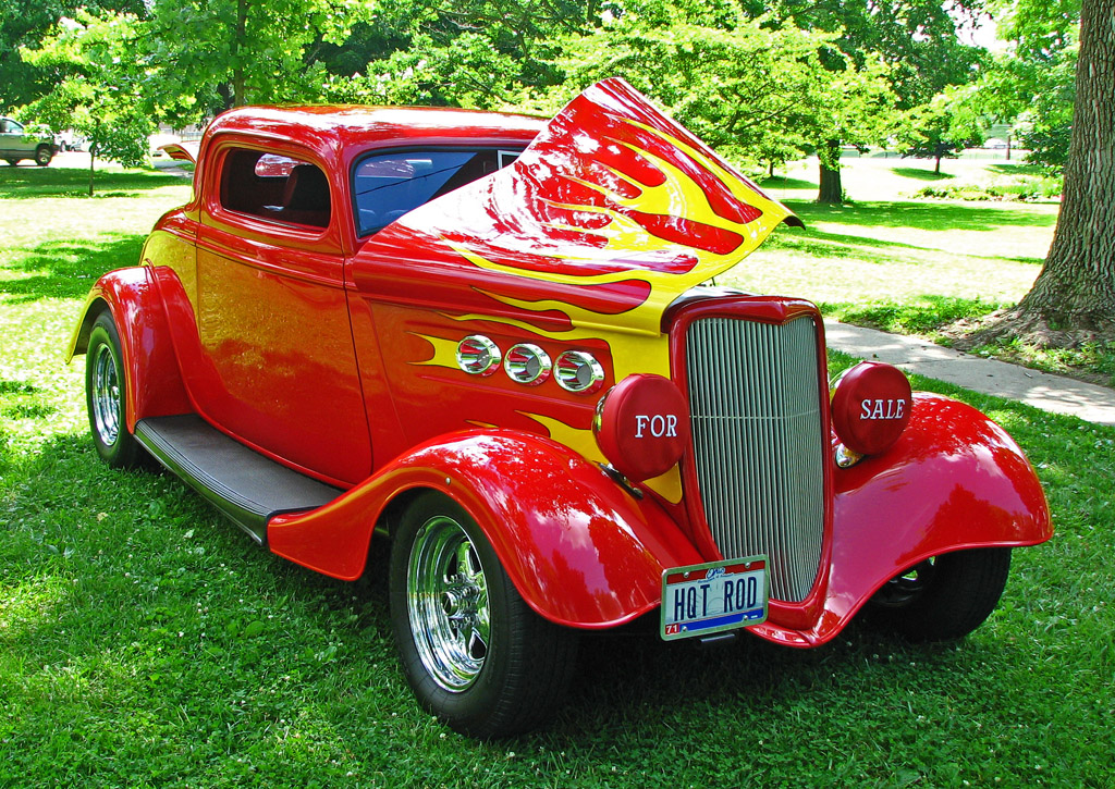 a car with an orange flame painted on the hood and engine