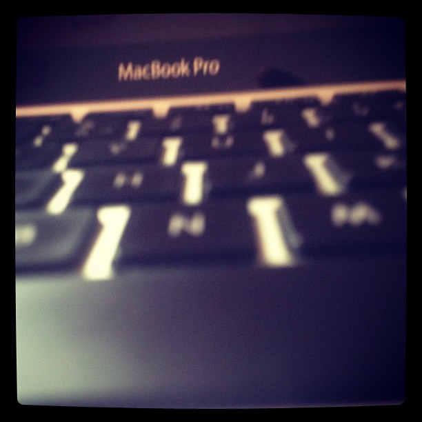 blurry image of laptop keyboard with a book pro sticker