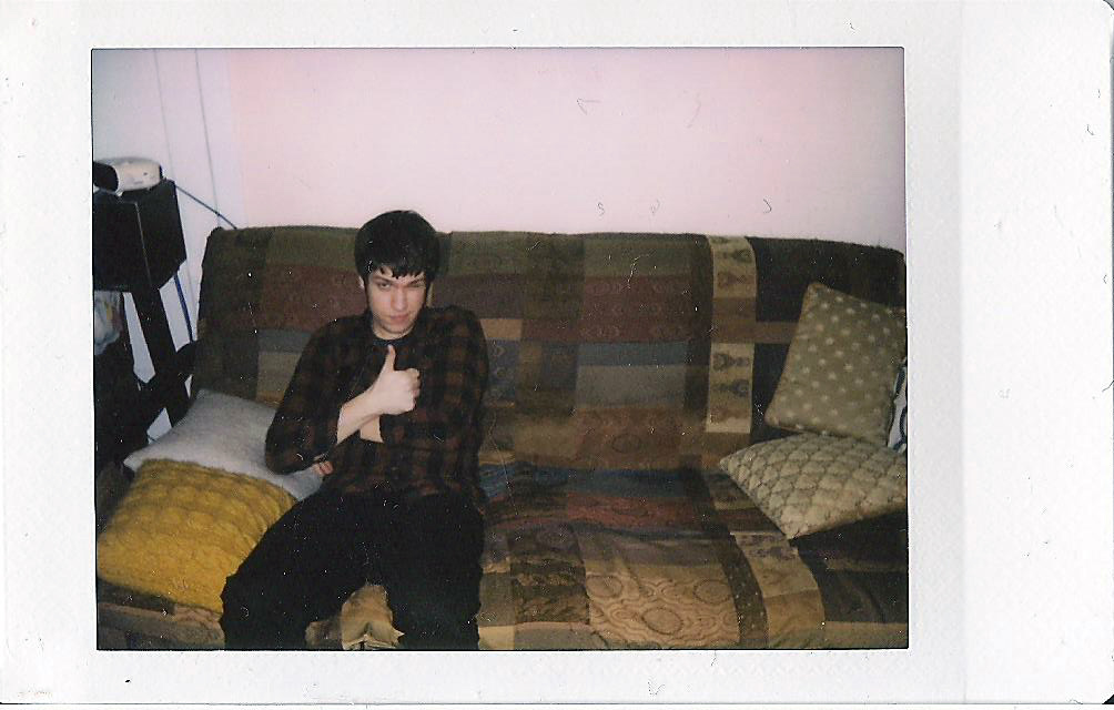 a boy with sunglasses on sitting on the couch
