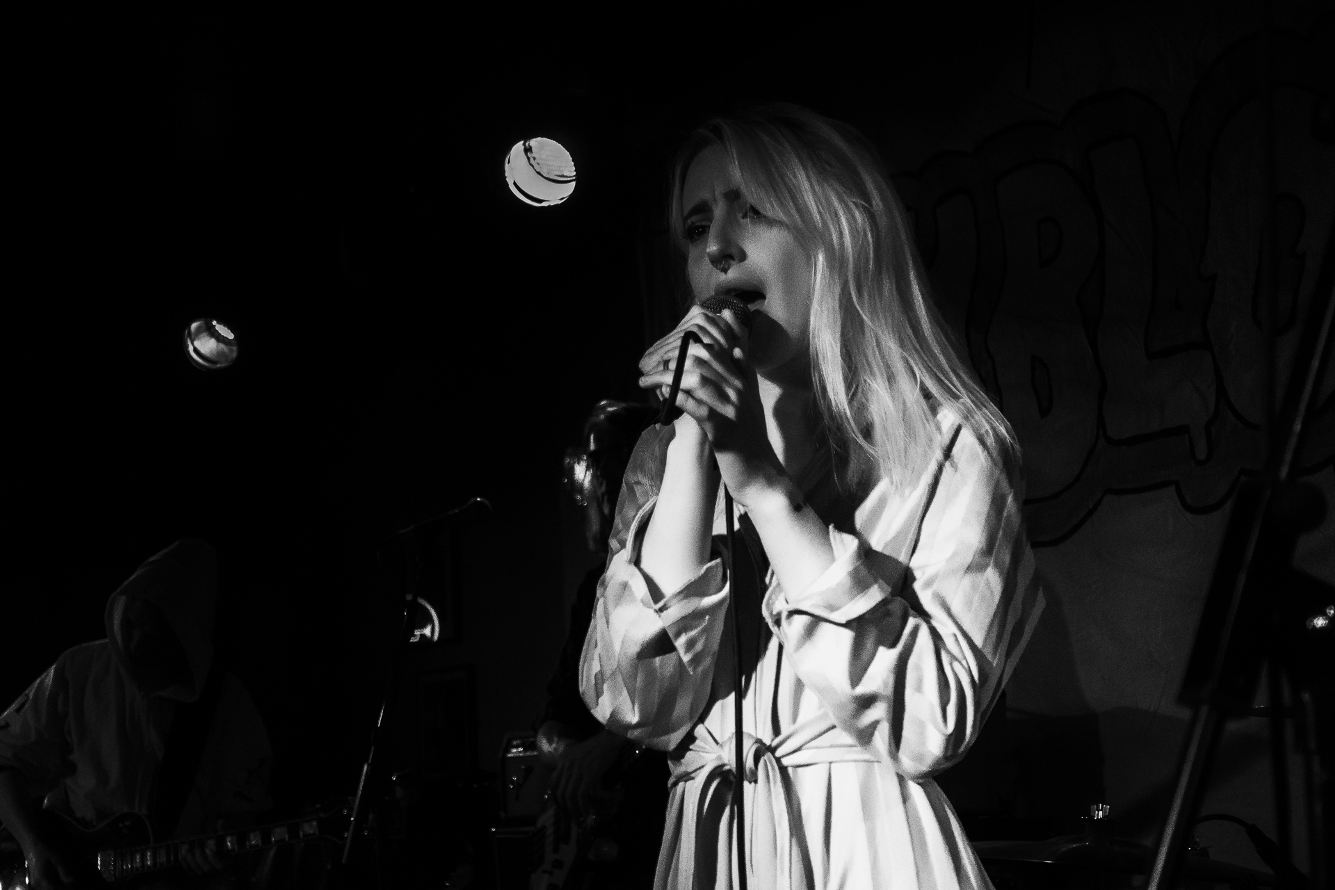 a woman with long white hair standing next to a microphone