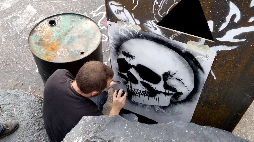 a man is painting a skull on a street