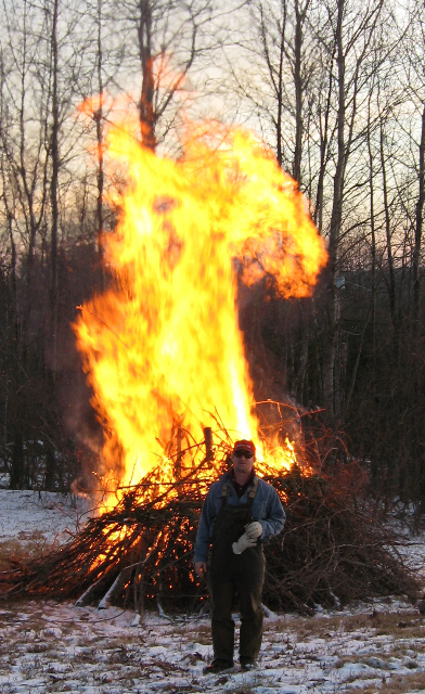 a person standing by a fire in the snow