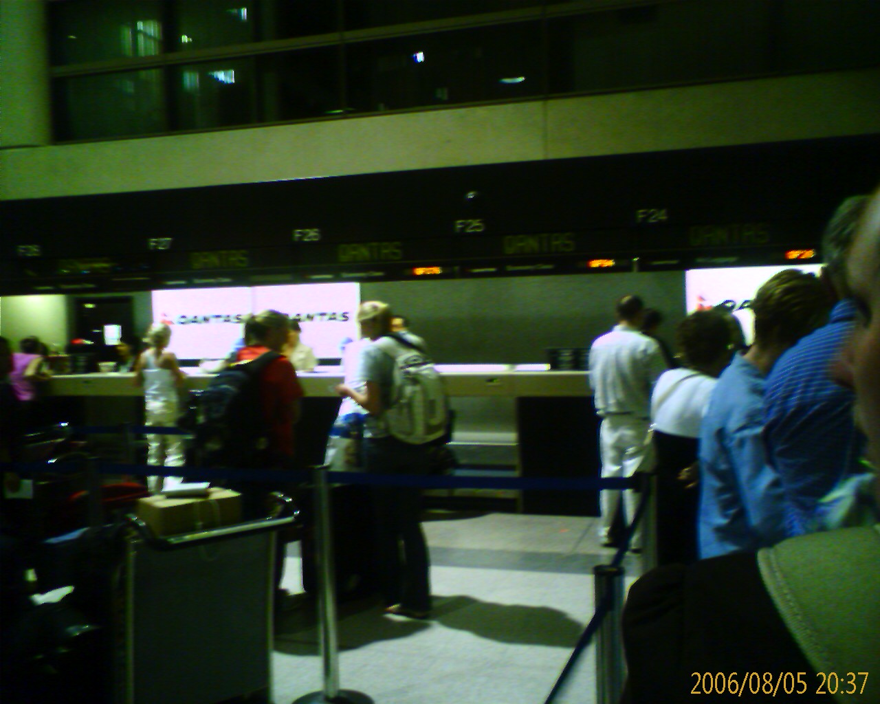 people waiting in line at the airport to get their luggage